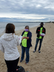 Tracy Taylor and Beni Lapika speak with a beach goer at OOB.